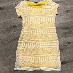 Large yellow and white dress with lace overlay.